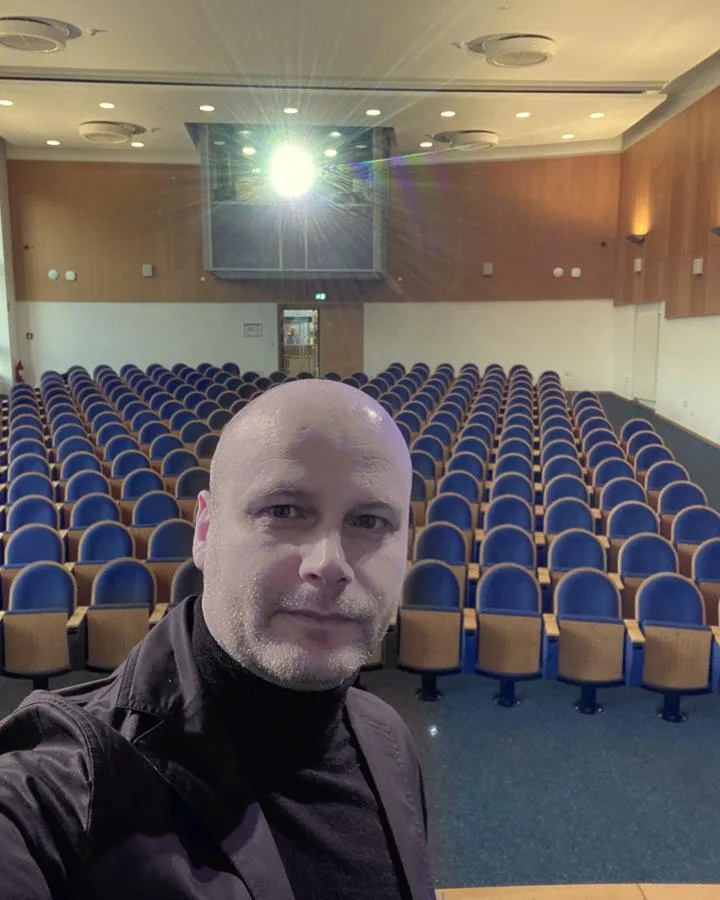 David Hirschhäuser vor einem leeren Hörsaal kurz vor einem Vortrag